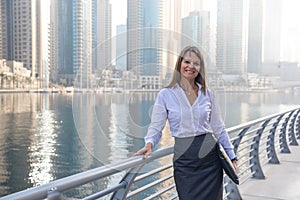 Business woman with a portfolio on a boardwalk.