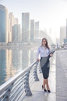 Business woman with a portfolio on a boardwalk.