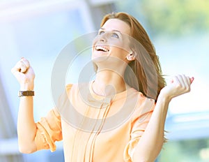 Business woman portrait smiling and rejoicing his success raising arms up