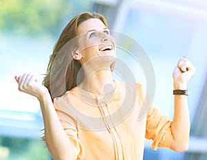 Business woman portrait smiling and rejoicing his success raising arms up