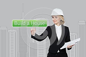 Business woman pressing build a hause button on virtual screens. Residential Blocks. Business, technology, internet and