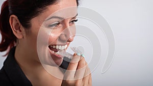 Business woman puts on transparent retainers to straighten teeth