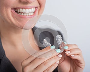 Business woman puts on transparent retainers to straighten teeth photo