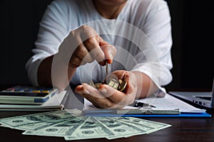 Business woman putting coin in hand on wood table background, saving money wealth and financial concept, finance, investment,