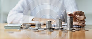 Business Woman putting a coin on a pile of coins. Placing coins in a row from low to high is comparable to saving money to grow