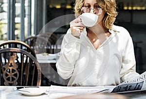 Business woman reading newspaper in the morning