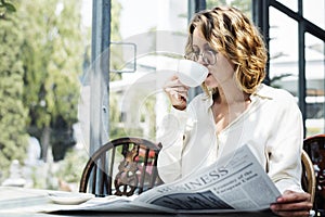 Business woman reading newspaper in the morning