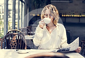 Business woman reading newspaper in the morning