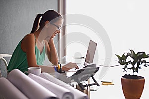 Business woman, reading and typing on laptop for planning, research and real estate website in her home office