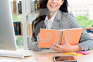 Business woman reads book at office desk