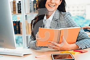 Business woman reads book at office desk Jivy
