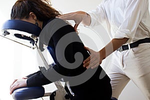 Business woman receiving shiatsu on a massage chair