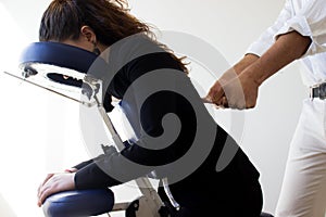 Business woman receiving shiatsu on a massage chair