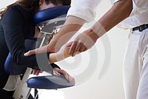 Business woman receiving shiatsu on a massage chair