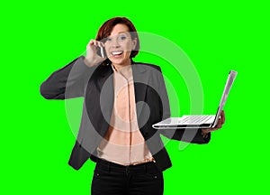 Business woman with red hair talking on the mobile cell phone holding laptop in hand isolated on green screen croma