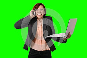 Business woman with red hair talking on the mobile cell phone holding laptop in hand isolated on green screen croma
