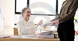 A business woman refuses to take papers from a colleague