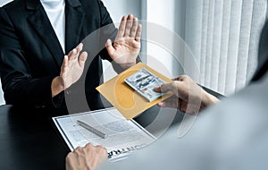 Business woman refusing and don`t receive money banknote in envelope offer from business people to accept agreement contract of