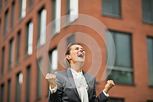 Business woman rejoicing in front of office photo