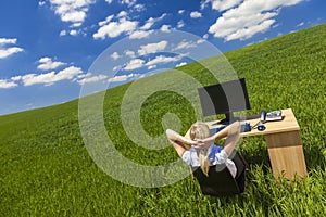 Business Woman Relaxing at Desk in Green Field Office