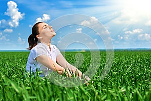 Business woman relaxing in green grass field outdoor under sun. Beautiful young girl dressed in suit resting, spring landscape, br