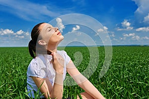 Business woman relaxing in green grass field outdoor under sun. Beautiful young girl dressed in suit resting, spring landscape, br