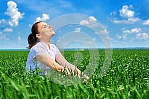 Business woman relaxing in green grass field outdoor under sun. Beautiful young girl dressed in suit resting, spring landscape, br