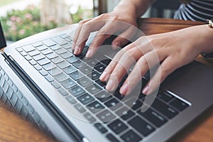 A business woman`s hands working and typing on laptop keyboard on the table