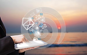 Business woman sending email marketing on the beach