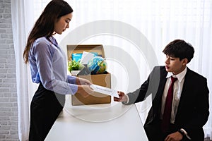 Business woman sending letter for resignation to boss with cardboard box in desk at office. Concept resign depress and resignation