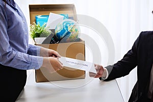 Business woman sending letter for resignation to boss with cardboard box in desk at office. Concept resign depress and resignation