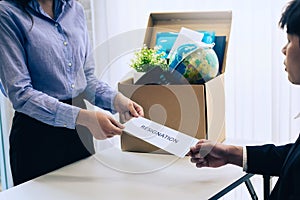 Business woman sending letter for resignation to boss with cardboard box in desk at office. Concept resign depress and resignation