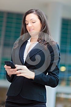 Business woman sending sms outdoor