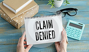Business woman shows a card with text Claim Denied