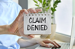 Business woman shows a card with text Claim Denied . Injury claim insurance concept