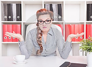 Business woman shrugging her shoulders in office