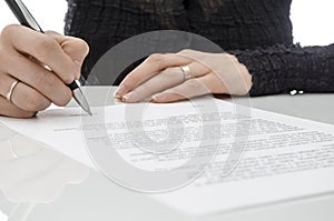 Business woman signing a contract above signature line