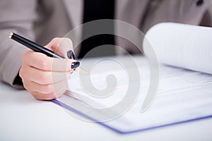 Business woman signing a contract above signature line