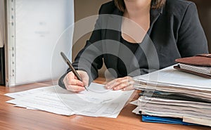 Business woman is signing contract in office