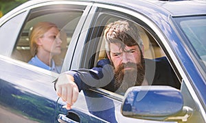 Business woman sit on backseat while bearded driver sit in front. Car with open windows and passenger. Business lady