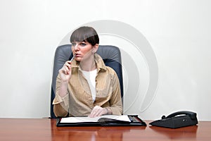 Business woman sitting behind the desk in the office, solving the problem photo