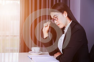 Business woman sitting at the desk and and thinking to her work