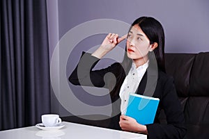 Business woman sitting at the desk and thinking to her work