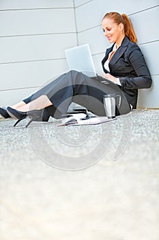 Business woman sitting on floor at office building