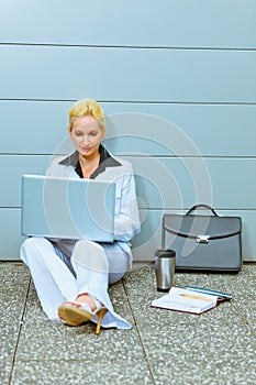 Business woman sitting on floor at office building