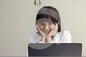 Business woman sitting at her desk with headset