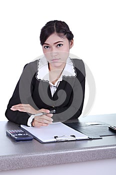 Business woman sitting on her desk holding a pen working with do