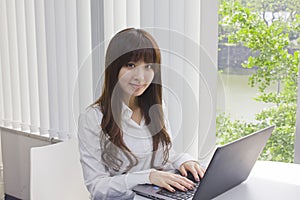 Business woman sitting at her desk with Laptop computer in office