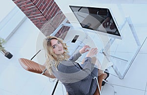 Business woman sitting at her Desk and looking at camera