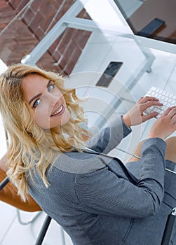 business woman sitting at her Desk and looking at camera